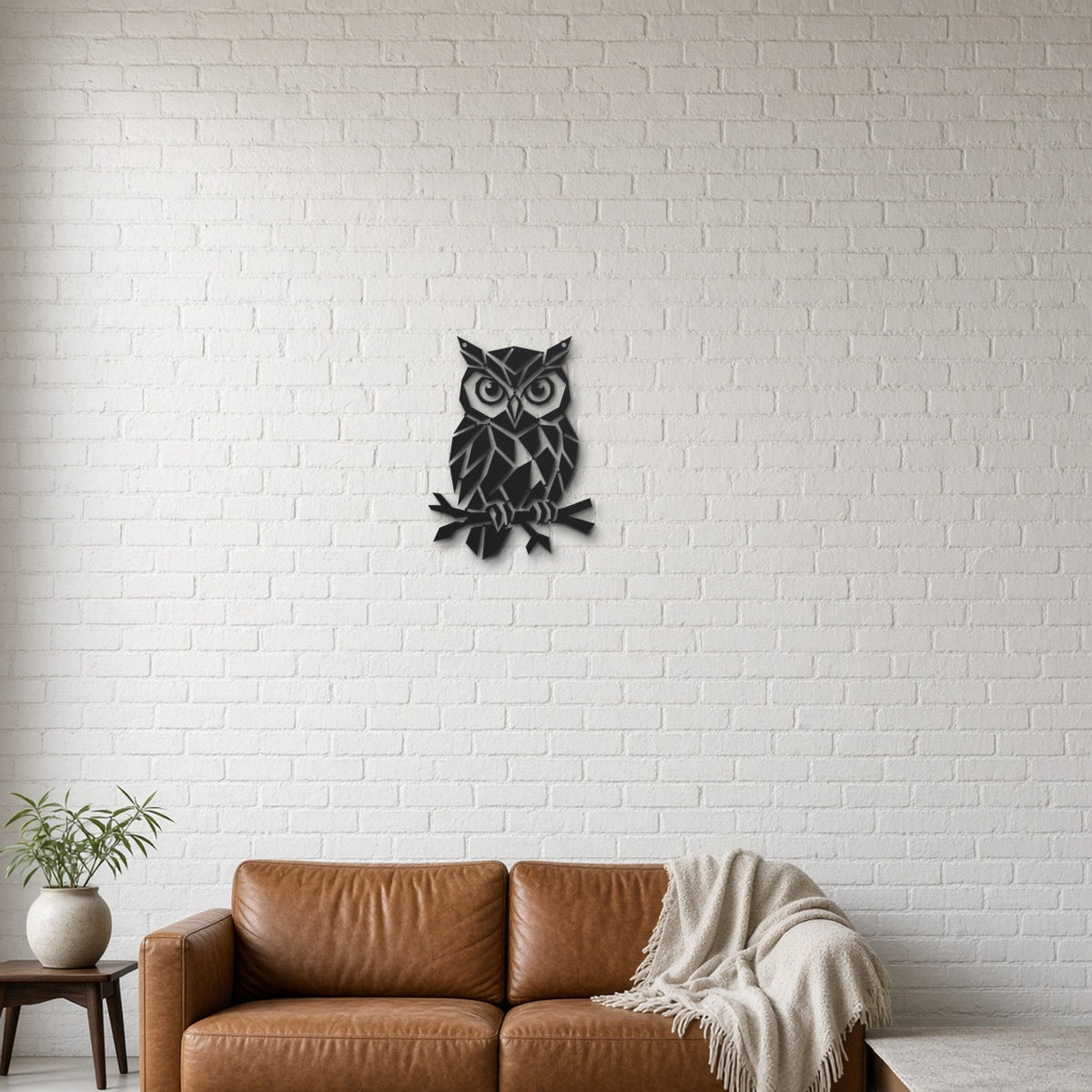 Geometric Owl black metal wall art hanging on a lounge with white brick wall wall