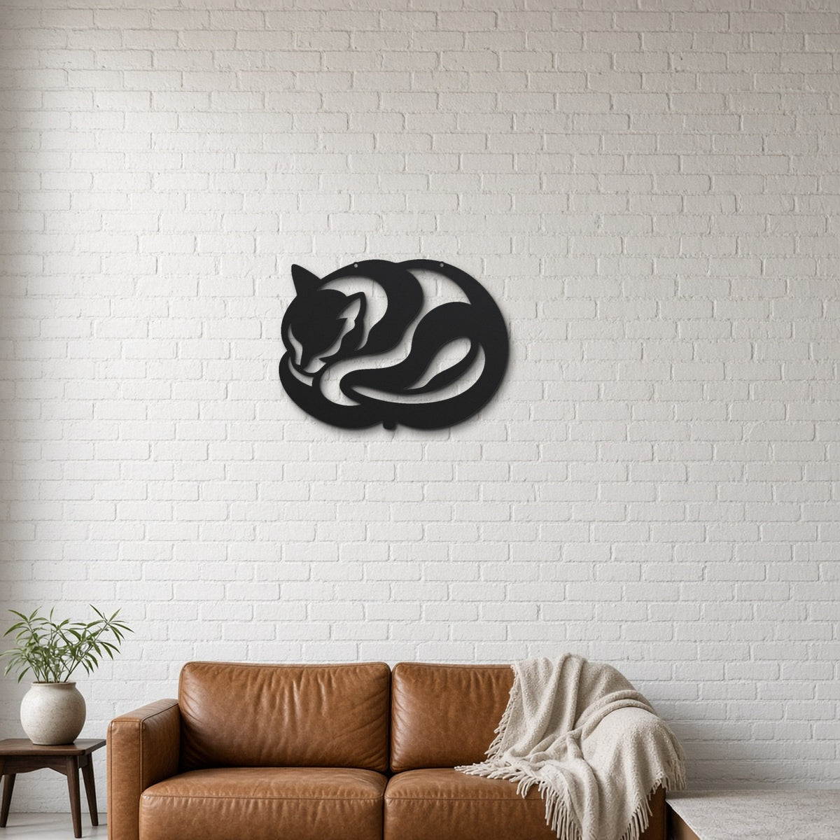 Sleeping Cat black metal wall art hanging on a lounge with white brick wall wall