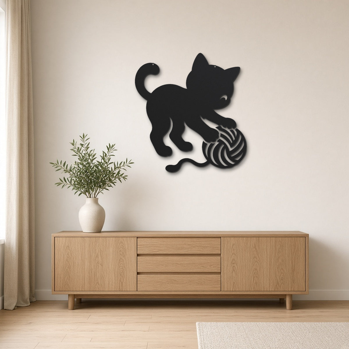 Cat Playing with Yarn black metal wall art hanging on a Scandinavian living room wall