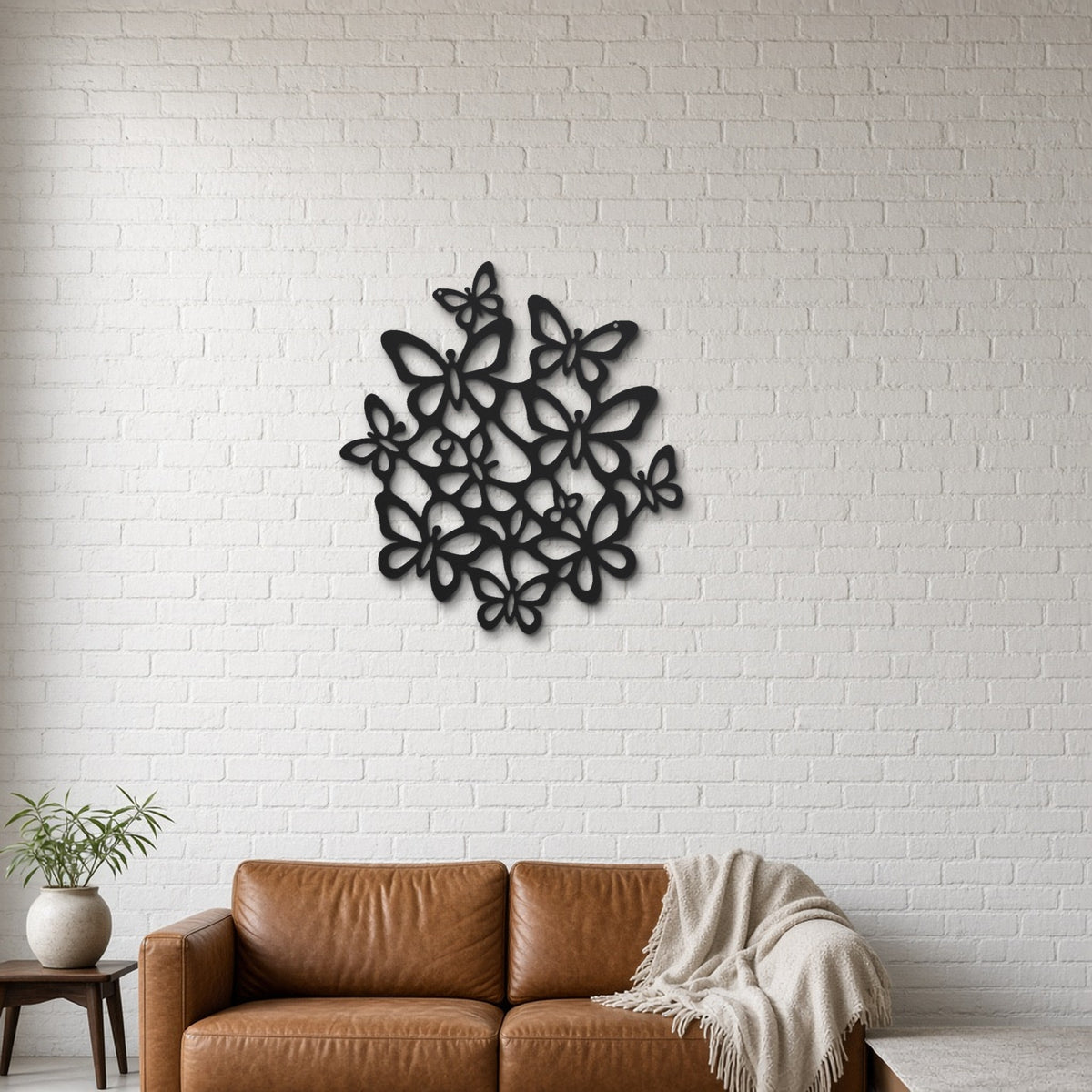 Butterfly Swarm black metal wall art hanging on a lounge with white brick wall wall