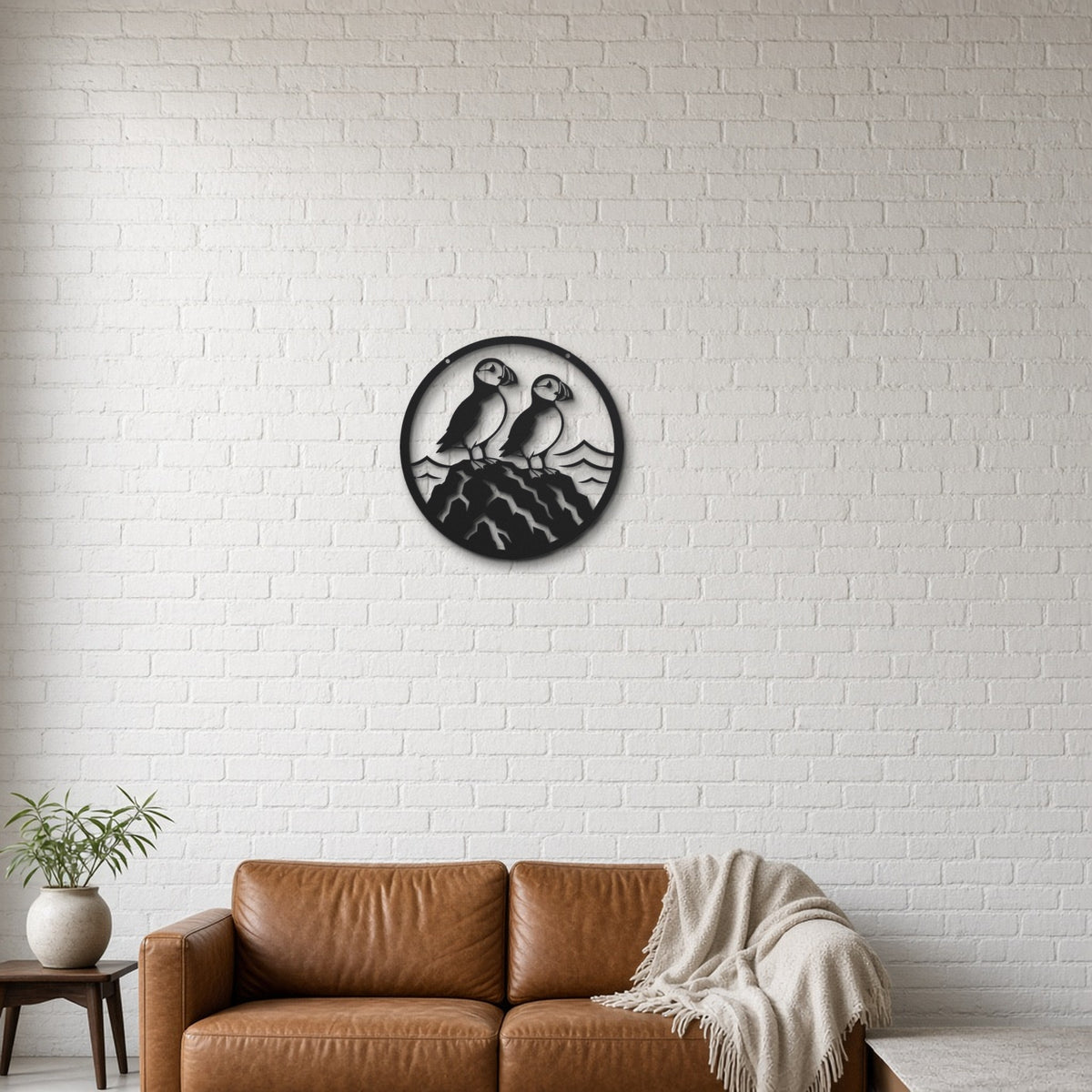 Puffin Pair black metal wall art hanging on a lounge with white brick wall wall