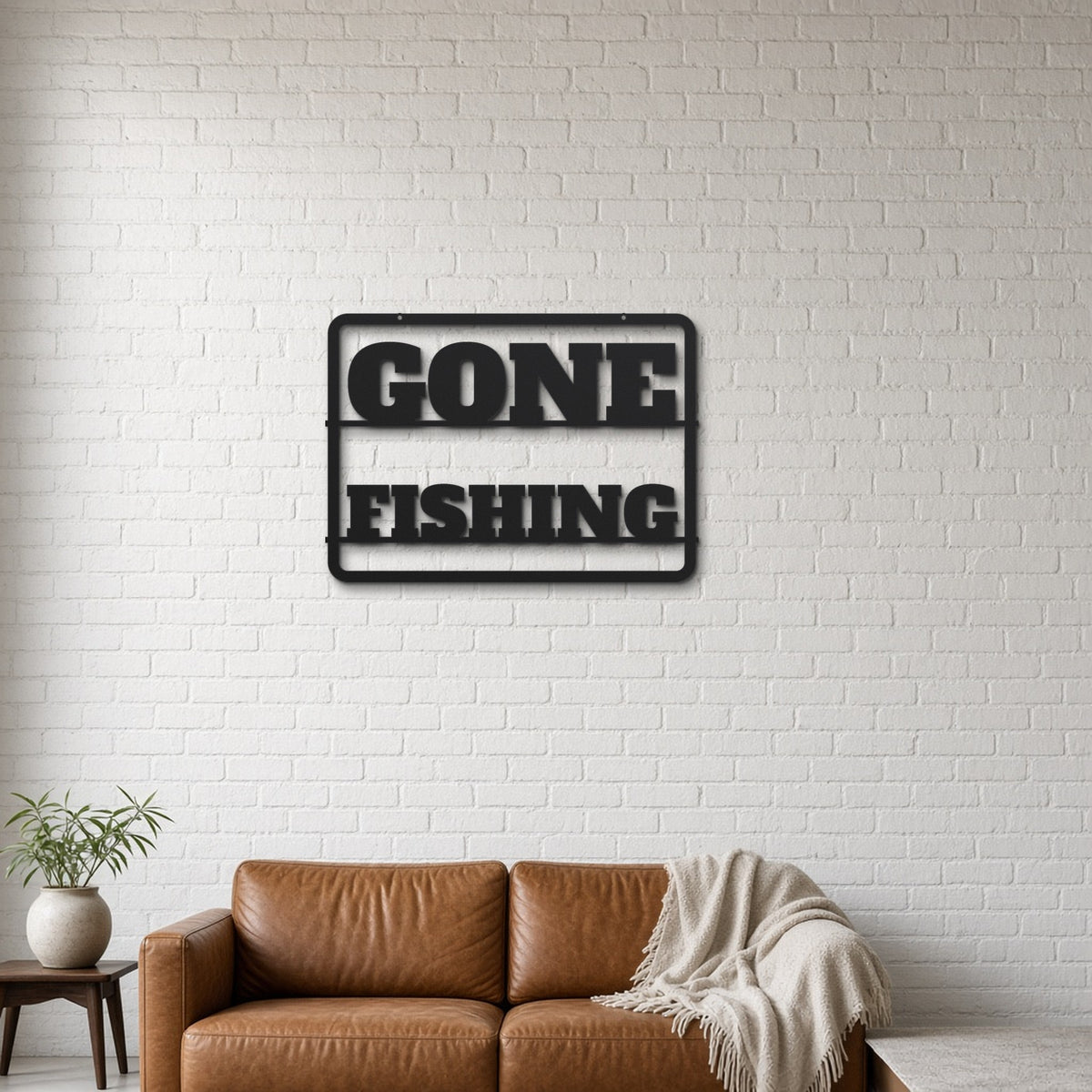 Gone Fishing black metal wall art hanging on a lounge with white brick wall wall